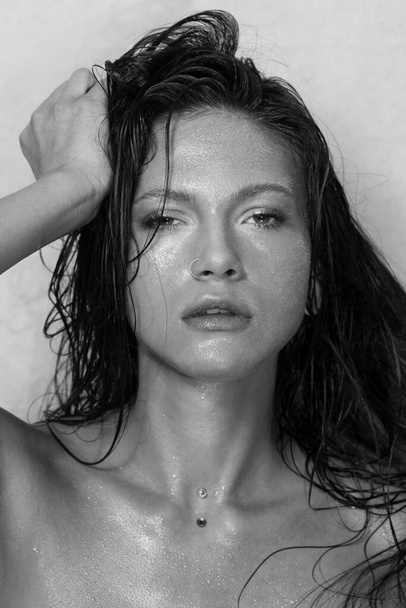 Close-up portrait of beautiful woman's purity face. Model with wet clean shiny skin. Small drops on the skin. Black and white photo. - Φωτογραφία, εικόνα