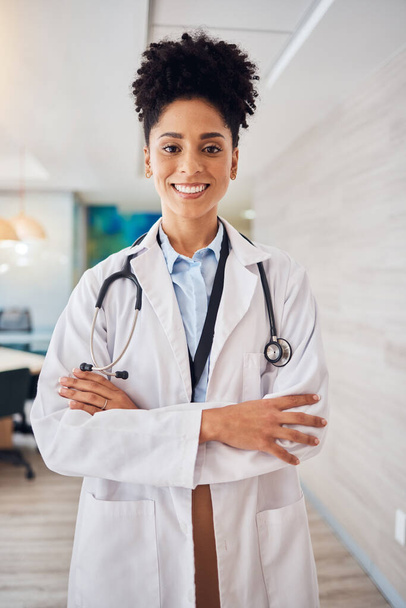 Portrait, black woman and doctor arms crossed, healthcare and smile in hospital, leader and confident. Face, African American female surgeon, employee or medical professional with skills or happiness. - Фото, изображение