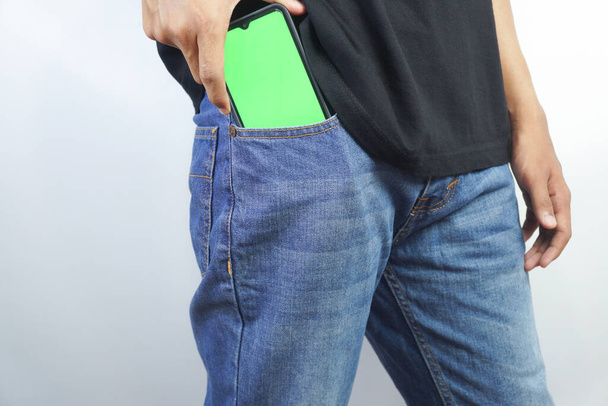 Man met Green Screen Chroma Key Smartphone op kantoor. Aziatische Persoon die internet, sociale media, online winkelen met mobiele telefoon apparaat gebruikt. Focus op display, Hand - Foto, afbeelding