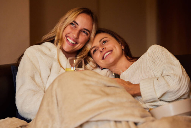 Comfy, laughing and lesbian couple watching tv on the sofa, movie or subscription service. Happy, together and friends relaxing on the couch for television, a show or streaming a funny video. - Φωτογραφία, εικόνα