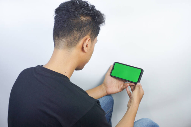 Close up shot of man holding a smartphone with chroma key mock up green screen - technology, connections, communications concept - Foto, afbeelding