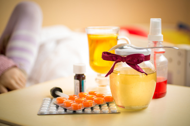 foto de té, tarro de miel y pastillas tumbadas en la mesa en el dormitorio
 - Foto, imagen
