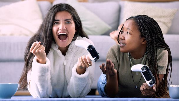 Celebrate, controller and friends playing a game in the living room for entertainment, fun and bonding. Happy, celebration and interracial women enjoying a gaming competition together at their home - Photo, Image