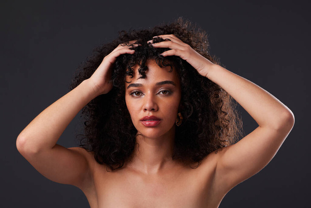 Portrait, natural and hair by black woman in studio for beauty, treatment and body care on black background. Face, girl and curly afro model relax with luxury, soft and glowing skin while isolated. - Fotoğraf, Görsel