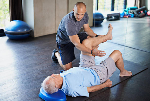 Cropped shot of a handsome personal trainer with a senior man. - Photo, image