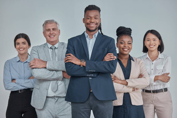 Leadership, team and business people with crossed arms in a studio with confidence, unity and teamwork. Collaboration, corporate and portrait of a group of employees standing by a gray background - 写真・画像