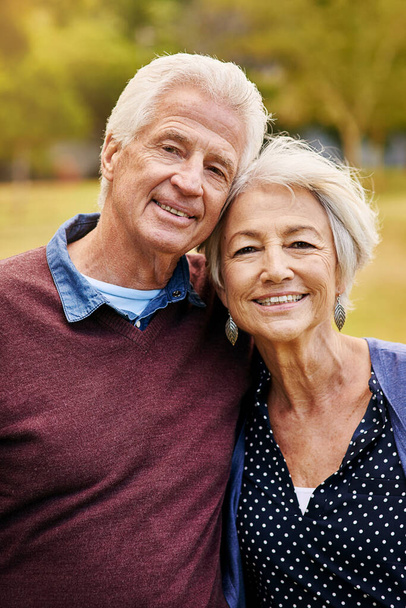 Old couple in portrait, outdoor in the park with smile, happiness together with bonding in nature, love and retirement. Happy, man and woman with travel, relationship with marriage and commitment. - Foto, imagen