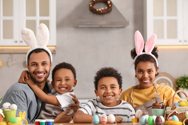 幸せなアフリカ系アメリカ人の家族の絵キッチンでテーブルでイースターエッグ - 写真・画像