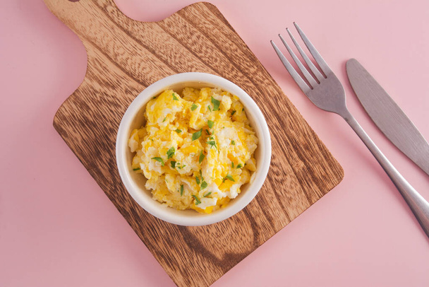 Scrambled eggs on bowl, pink background, top view - Foto, immagini