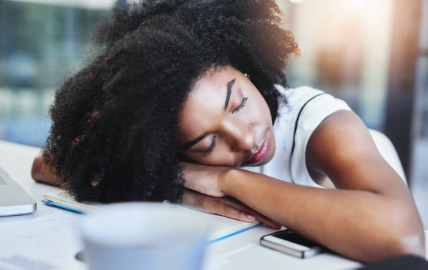 Schnappschuss einer attraktiven jungen Geschäftsfrau, die auf ihrem Schreibtisch in ihrem Büro schläft. - Foto, Bild