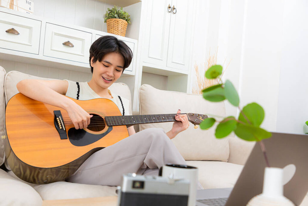 Mujer tocando guitarra acústica instrumento de música en casa. - Foto, imagen