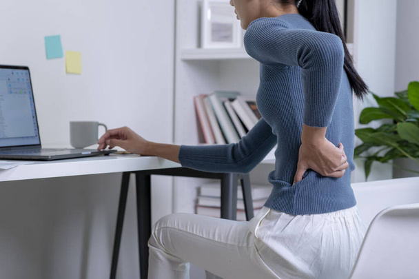 Asian young attractive woman pain with back pain ache from computer work. - Photo, image