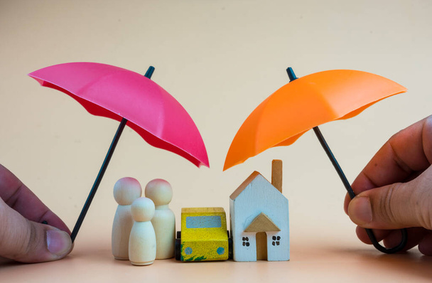Az ügynökség megvéd egy családot, otthont és autót két esernyővel és kettős biztosítással. Irányítási és biztosítási koncepció. - Fotó, kép