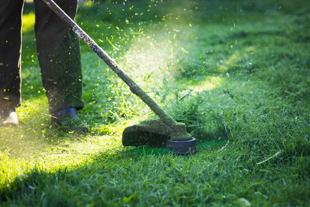 Mowing the grass with a lawn mower. Garden work concept background. - Foto, Imagem