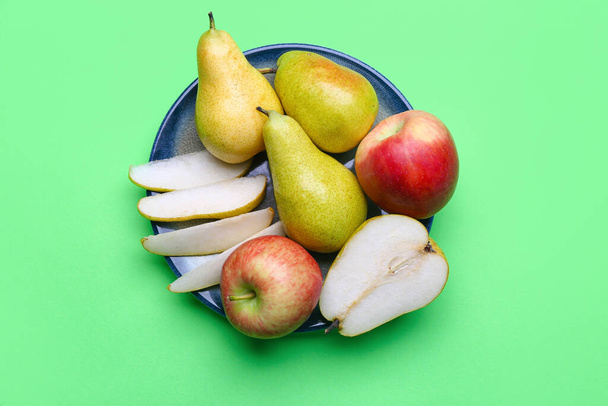 Plate with fresh pears and apples on color background - Fotoğraf, Görsel