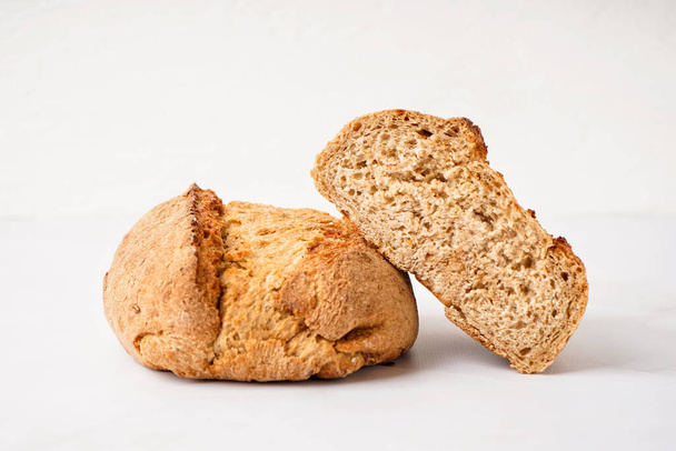 gesneden brood van vers brood op witte tafel - Foto, afbeelding