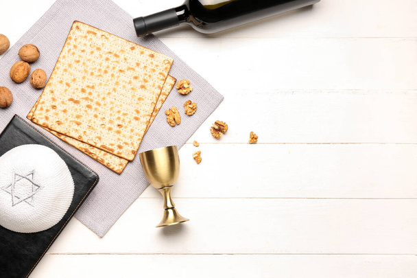 Composition with flatbread matza, walnuts, kippah and cup on white wooden background - Zdjęcie, obraz