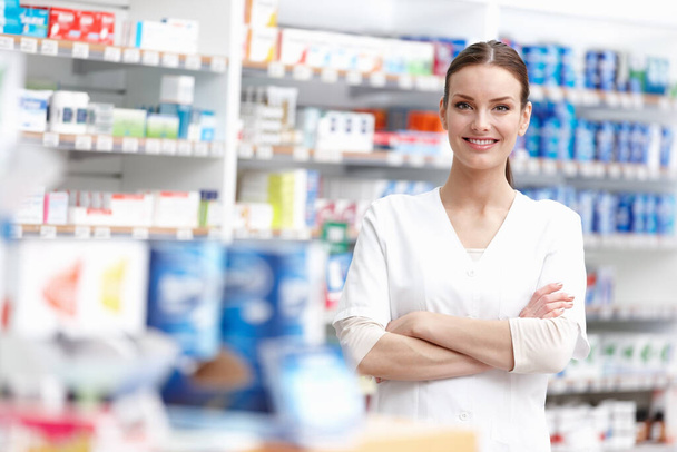 Smiling pharmacist with hands folded. Portrait of young pharmacist smiling with hands folded at medical store - Foto, Imagen