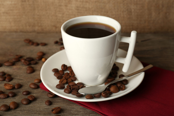 Cup of coffee with beans on rustic wooden background - Foto, Imagen