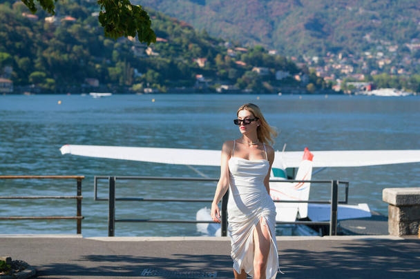 Travel tourist woman in Como lake Italy Europe. Girl on summer vacation visiting famous tourist destination. Luxury travel in Como lake Italy. Beautiful young woman enjoying vacation during summer - Foto, afbeelding