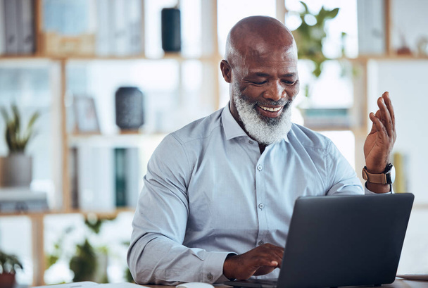 Laptop, online meeting και Αφρικανός επιχειρηματίας στο γραφείο σε μια εικονική εταιρική συζήτηση. Ευτυχής, ηγεσία και ανώτερος υπάλληλος που μιλάει σε βιντεοκλήση ή webinar με υπολογιστή στο χώρο εργασίας - Φωτογραφία, εικόνα