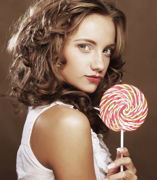 curly  girl with a lollipop in her hand - Foto, afbeelding