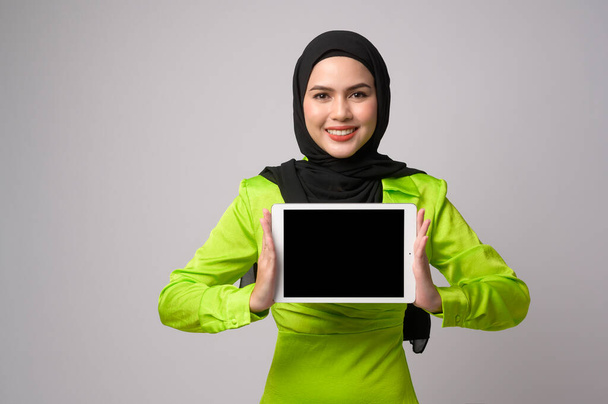 A Beautiful musllim woman with hijab using tablet over white background, technology concept. 	 - Valokuva, kuva
