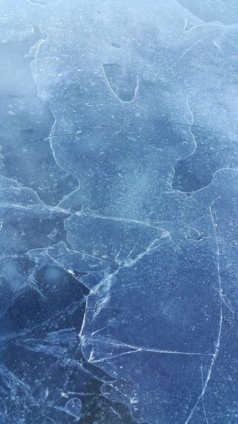 Brittle ice on the surface of a frozen river, close-up natural winter background - Foto, Imagen