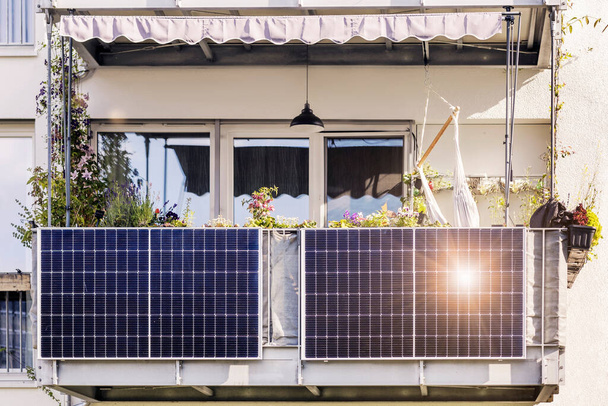 Aurinkopaneeli modernin kerrostalon parvekkeella kaupungissa auringon valon heijastuksella. Pieni paikallinen aurinkopaneelijärjestelmä Eco Flat. - Valokuva, kuva