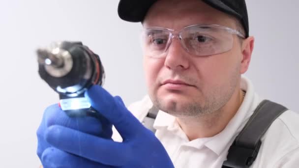 Close-up of the face of a handyman in safety glasses holding a screwdriver. Repair in the apartment - Materiał filmowy, wideo