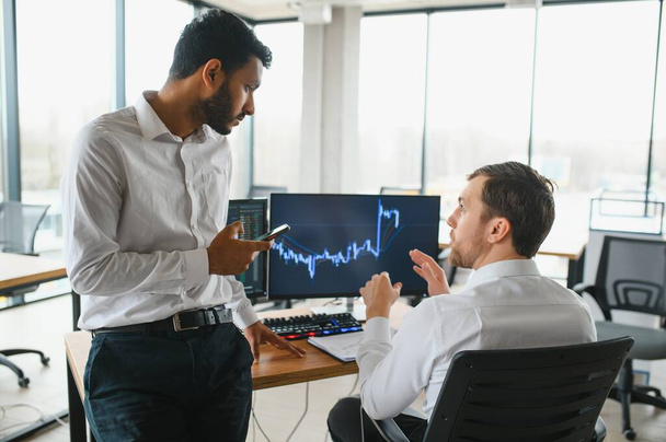 Two diverse crypto traders brokers stock exchange market investors discussing trading charts research reports growth using pc computer looking at screen analyzing invest strategy, financial risks - Fotografie, Obrázek