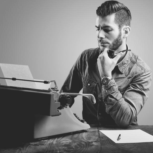 Young man with beard and mustache at the typewriter while smokin - Photo, Image