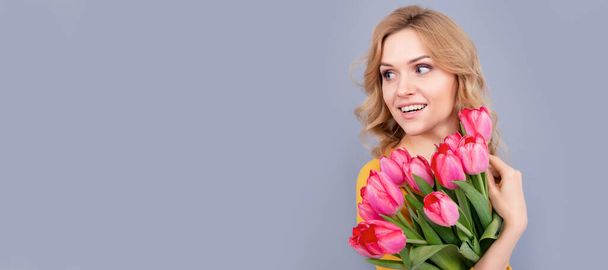Woman isolated face portrait, banner with mock up copy space. positive woman with tulips. lady hold flowers for spring holiday. girl with bouquet - Photo, image