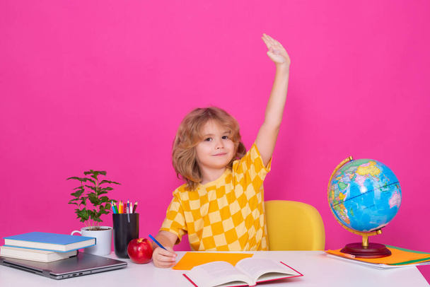 School child raising hands, willing to answer question. Smart caucasian school boy kid pupil student going back to school. School child isolated on red pink studio background - Foto, Imagen