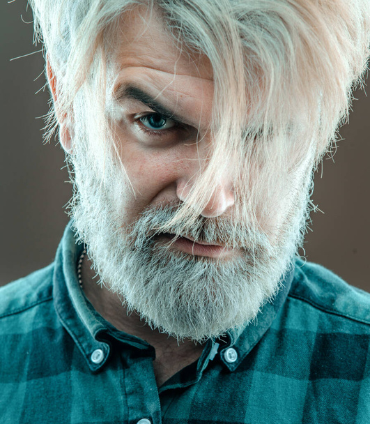 Close up face of fashionable latin man on grey background. Guy with beard and modern hairstyle in the studio - Fotografie, Obrázek