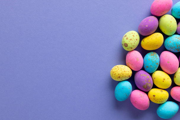 Image of multi coloured chocolate easter eggs with copy space on purple background. Easter, religion, tradition and celebration concept. - Фото, зображення