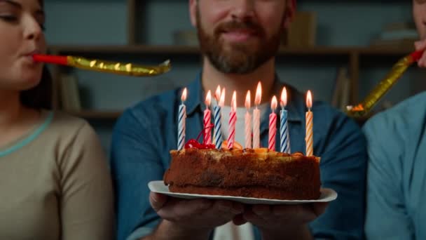 Обрізаний вид невідомий кавказький дорослий щасливий бородатий чоловік святкує день народження вдома різноманітні африканські друзі вітають чоловіка зі святковим пирогом, що дме з несподіваною традицією
 - Кадри, відео