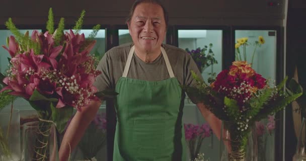 Egy japán virágárus portréja, amint a műhely mögötti kamera előtt mosolyog. Egy ázsiai férfi, boldog arckifejezéssel. Munkahelyi foglalkozás fogalma - Felvétel, videó