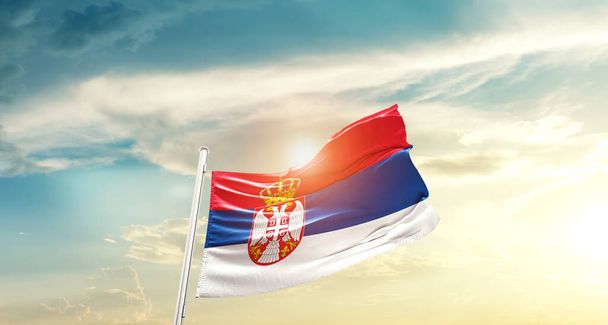 Serbia waving flag in beautiful sky with sun - 写真・画像