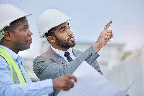 Engineering, teamwork and leader with blueprint at construction site for development. Architecture, collaboration and manager, contractor men or architect colleagues pointing, planning and discussion. - Photo, image
