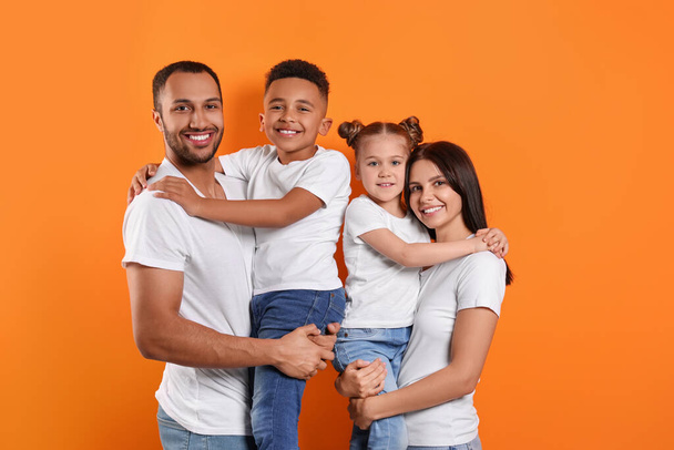 Happy international family with children on orange background - Фото, изображение