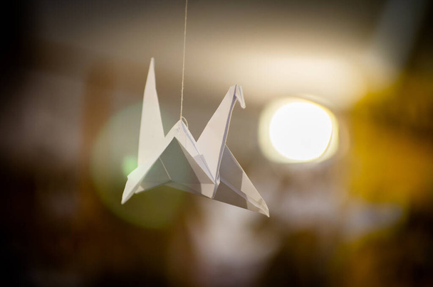 Japán hajtogatott Origami daruk lógnak zsinórral. Több száz kézzel készített papírmadár elkülönítve fénymásolási hellyel. 1000 ezer daru tsuru szobor téma. A béke, a hit, az egészség, a kívánságok, a remény szimbóluma - Fotó, kép