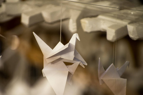 Japán hajtogatott Origami daruk lógnak zsinórral. Több száz kézzel készített papírmadár elkülönítve fénymásolási hellyel. 1000 ezer daru tsuru szobor téma. A béke, a hit, az egészség, a kívánságok, a remény szimbóluma - Fotó, kép