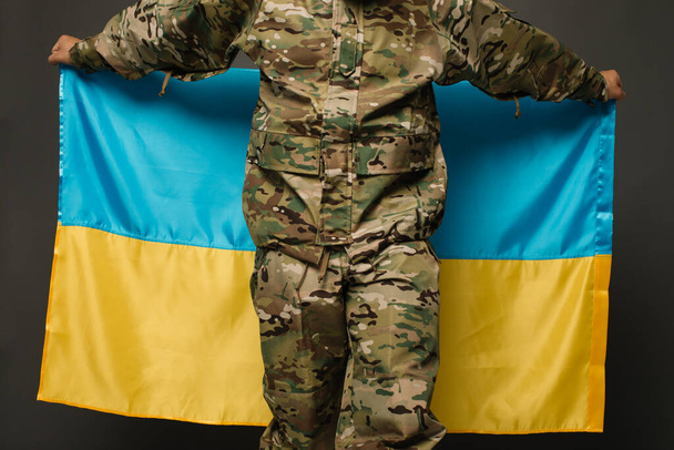 Portrait of a courageous Ukrainian military man holding the flag of Ukraine, freedom concept - Foto, Imagem