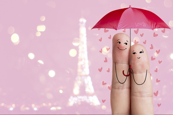 Finger art. Lovers is embracing and holding red umbrella against the background оf the Eiffel tower. Paris. Stock Image - Photo, Image