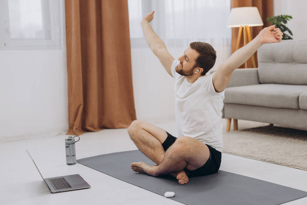 Bleiben Sie in Quarantäne ruhig. Millennial-Typ meditiert mit Trainer online über Laptop-Verbindung, leerer Raum - Foto, Bild