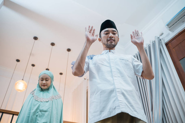 Asian Muslim men praying with women during Itidal prayer movement while praying at home - Foto, Bild