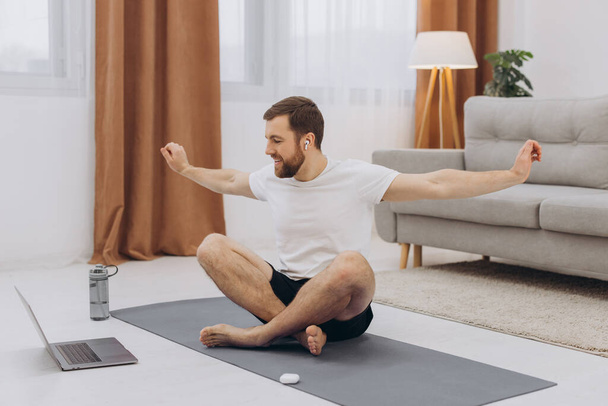 Keep calm on quarantine. Millennial guy meditating with trainer online via laptop connection, empty space - Fotografie, Obrázek