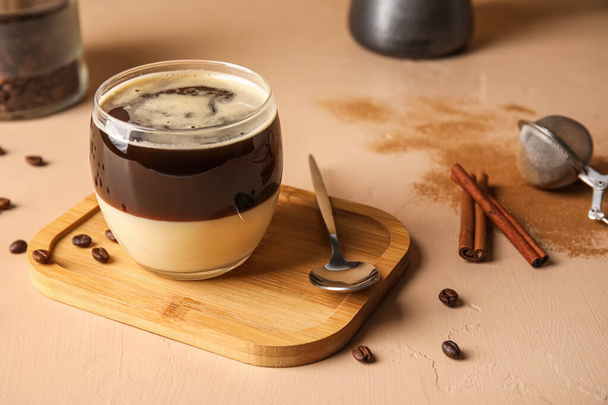 Wooden board with glass of tasty Cafe Bombon on color background - Photo, Image
