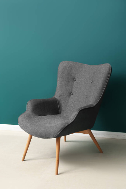 Moderner grauer Sessel nahe grüner Wand - Foto, Bild